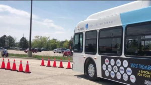 city bus driving between two rows of orange cones