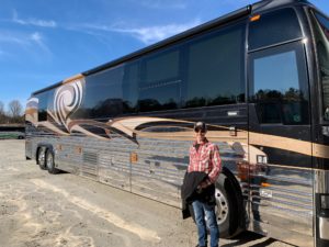 driver standing next to a fancy tour bus after completing cdl training Nashville TN